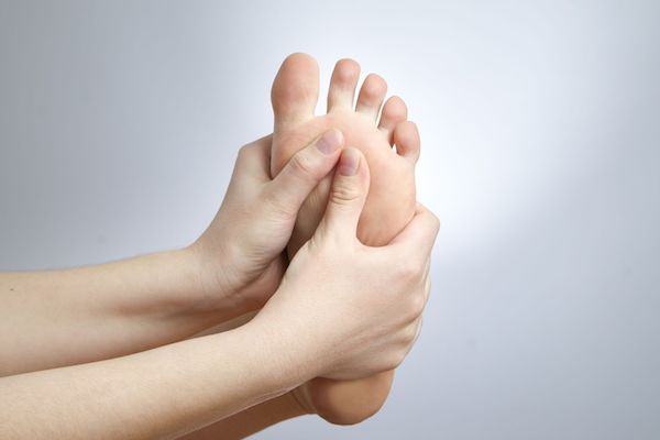 A woman holding her foot in pain