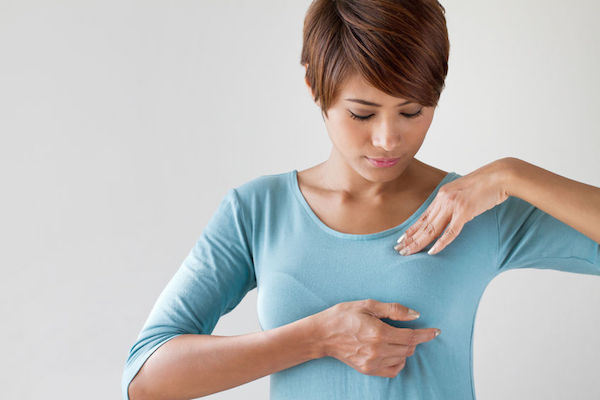 A woman checking her breast for cancerous lumps
