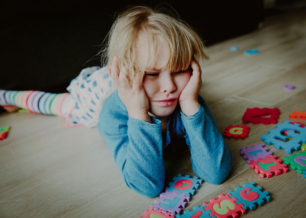 A young frustrated girl with toys