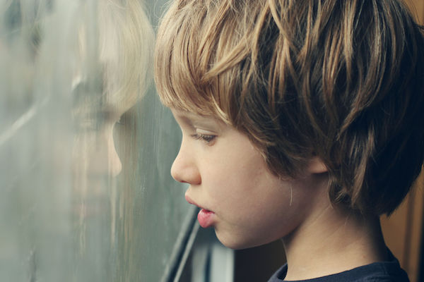 A boy with autism looking out a window