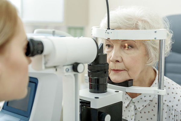 An elderly woman having her eyes checked by an optometrist