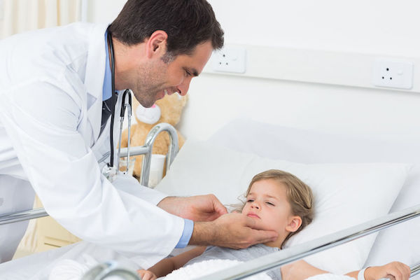 A young boy being examined by a doctor for mumps