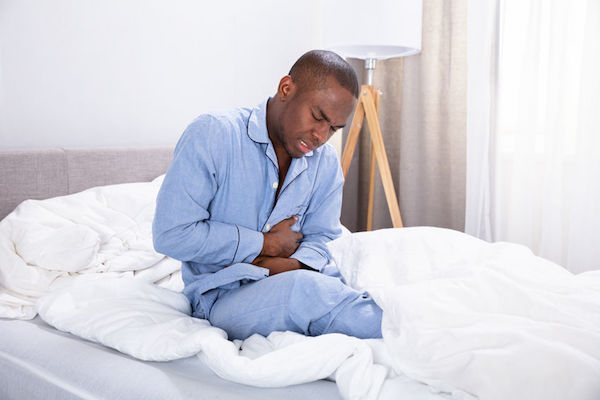 A man with a stomach ulcer in bed